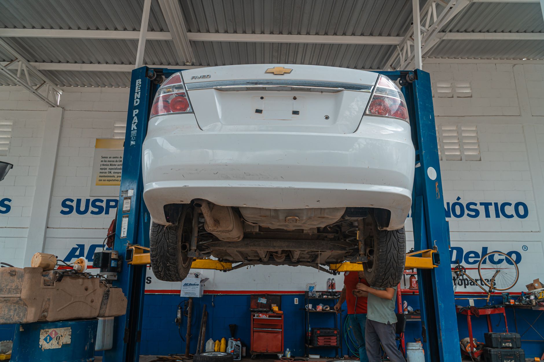 Dílna AutoMistr — mechanik u zdviženého vozu